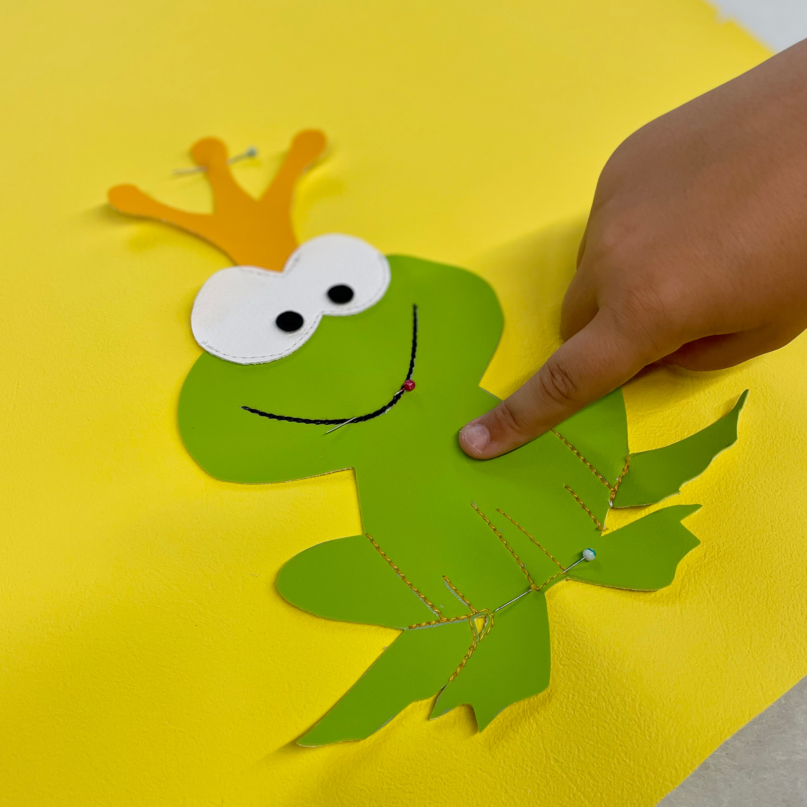 Das Rückendetail zum Kindersofa Froschkönig wird aufgenäht Der Froschkönig für unser Kindersofa in Handarbeit