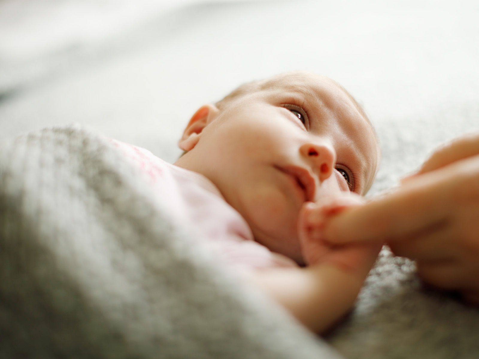 Geborgen in Liebe Baby greift nach Finger